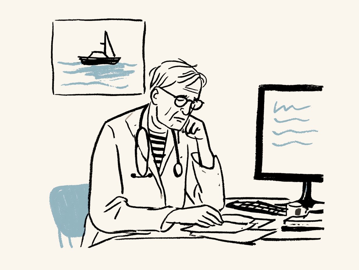 A clinician at a desk reviewing paperwork, a sailboat picture on the wall behind